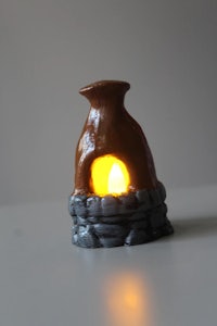 a small figurine with a candle sitting on top of it