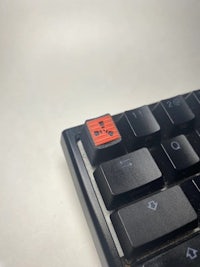 a black keyboard with a red button on it